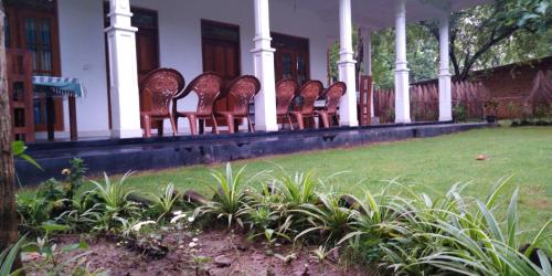 a row of chairs sitting on the porch of a house at Thuruliya Residence in Sigiriya