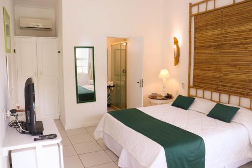 a bedroom with a bed and a television in it at Pousada Bucaneiro in Búzios
