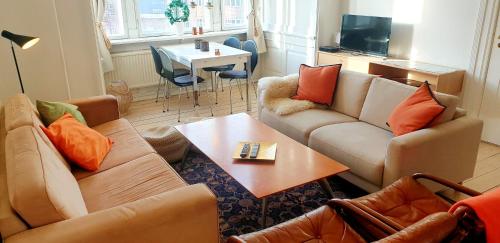 a living room with two couches and a table at Aaboulevard Apartment in Copenhagen