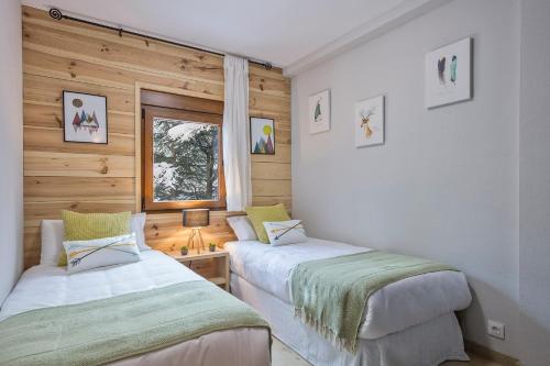 Naut AranにあるApartamento Renovado Baqueira 1500のベッド2台 木製の壁の部屋