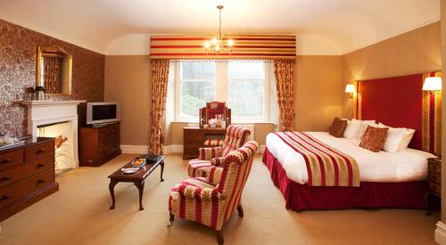 a hotel room with a bed and a chair at Lindeth Fell Country House in Bowness-on-Windermere