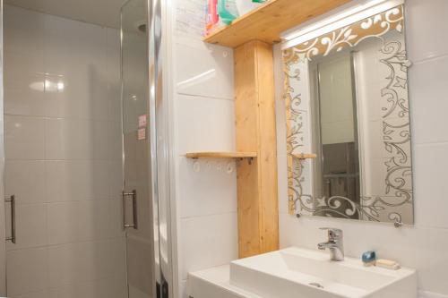 une salle de bain avec un lavabo, un miroir et une douche dans l'établissement PROMO Maisonnette donnant sur la Pinède, à Lacanau-Océan