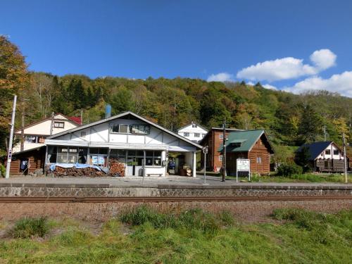 a train station with a building next to a train track at Ekinoyado Hirafu in Kutchan