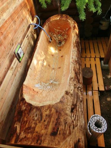 a wooden bath tub sitting on top of a wooden table at Ekinoyado Hirafu in Kutchan