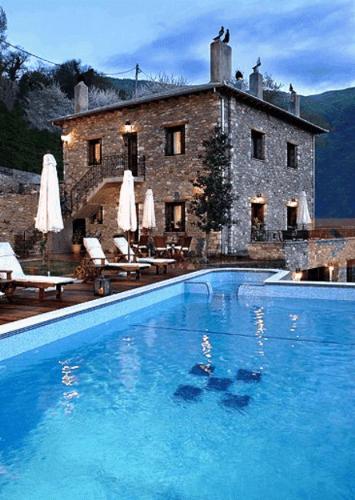 a large blue swimming pool in front of a building at Miression Pelion House in Mouresi