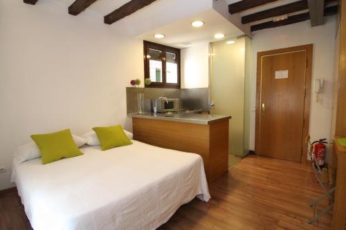 a bedroom with a white bed with green pillows at BCN2STAY Apartments in Barcelona