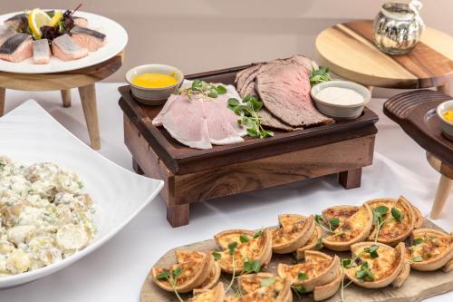a table topped with different types of food on plates at The Priest House On The River in Castle Donington
