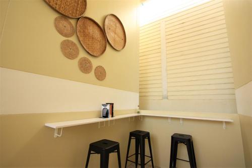 a room with three stools and a shelf with plates on the wall at Sun & Sea Nai Yang Phuket in Nai Yang Beach
