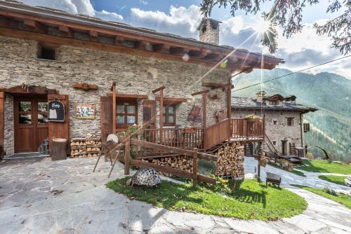 a stone house with a balcony in front of it at Brieis Relais Alpino in Marmora