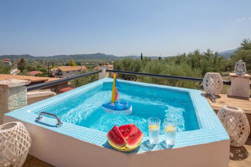 una piscina con rodajas de sandía y vasos de agua en Kali Tychi, en Katastárion