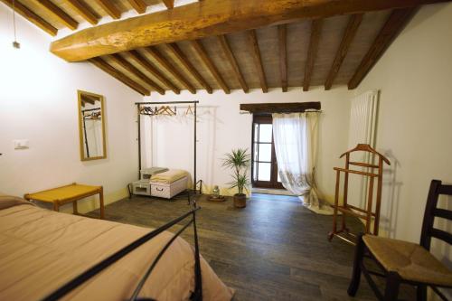 1 dormitorio con 1 cama y suelo de madera en Camere La Carbonaia, en Pienza