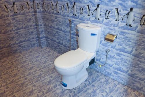 a white toilet in a bathroom with blue tiles at Blue Sky in Mirissa