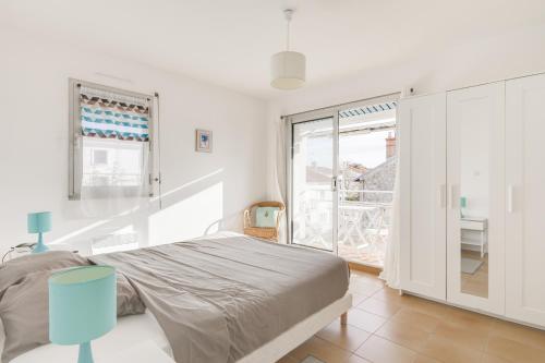 een slaapkamer met een bed en een groot raam bij Résidence Nathalie in Royan