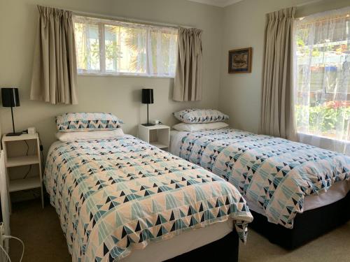 - une chambre avec 2 lits et une fenêtre dans l'établissement Harbour View Guesthouse, à Auckland