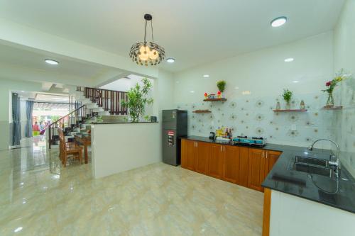 a large kitchen with a counter and a table at Coco Village Homestay Hoi An in Hoi An