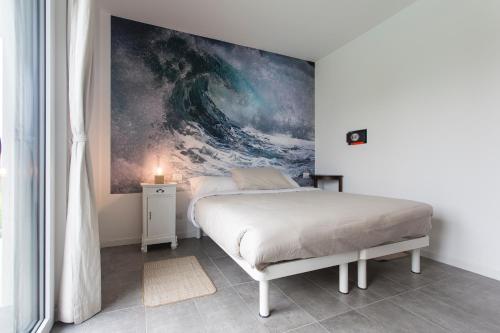 a bedroom with a bed with a painting on the wall at Aqua&Co Bellagio - Eco conscious stay in Bellagio