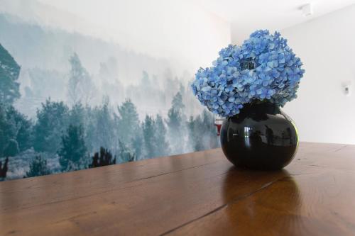 a vase filled with blue flowers sitting on a table at Aqua&Co Bellagio - Eco conscious stay in Bellagio