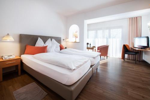 a hotel room with two beds and a television at Boutique Hotel Diana in Bad Füssing