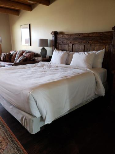 a bedroom with a large bed with white sheets and pillows at Abiquiu Inn in Abiquiu