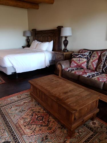 a bedroom with a bed and a couch and a coffee table at Abiquiu Inn in Abiquiu
