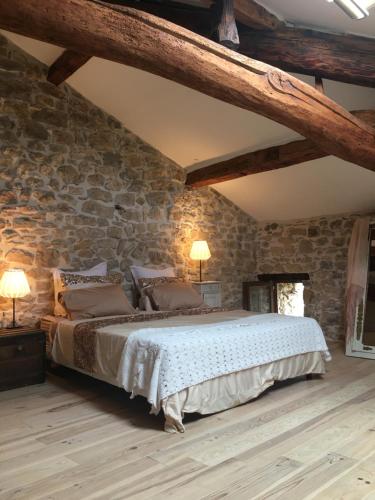 UzerにあるFort de la Bastideの石壁のベッドルーム1室(大型ベッド1台付)