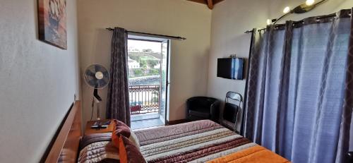 a bedroom with a bed and a window with a balcony at Marina de São Mateus in Angra do Heroísmo