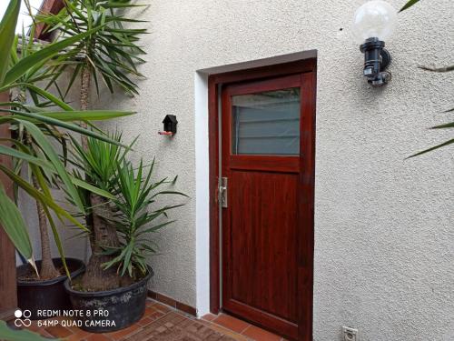 a wooden door on a white building with plants at Günther´s Ferienwohnung in Pegnitz