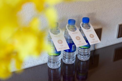 a group of four bottles of water with tags on them at Floral Hotel · Shangri-la Blue Sky in Shangri-La