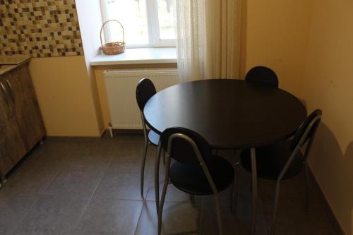 a black table and chairs in a room with a window at Comfortable Apartment close to Central Park in Tskaltubo