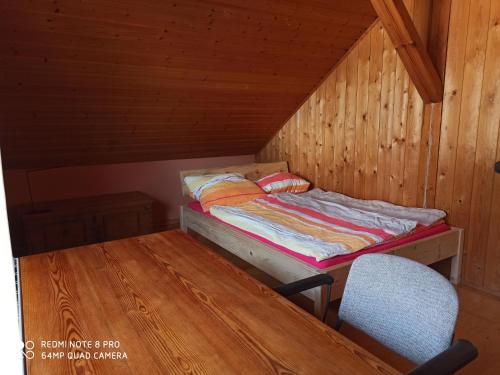 a bed in a cabin with a table and a chair at Günther´s Ferienwohnung in Pegnitz