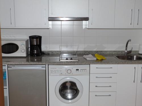 a kitchen with a washing machine and a sink at A dos pasos de Todo in Málaga