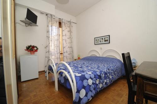 ein Schlafzimmer mit einem Bett und einem TV an der Wand in der Unterkunft B&B "La Camelia" in Rieti