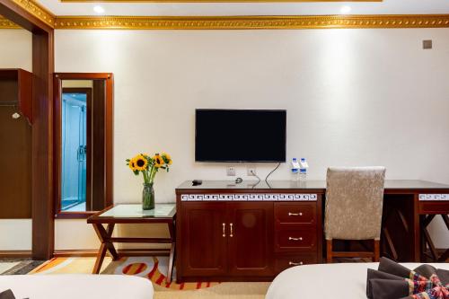 a living room with a flat screen tv on a wall at Floral Hotel · Shangri-la Blue Sky in Shangri-La
