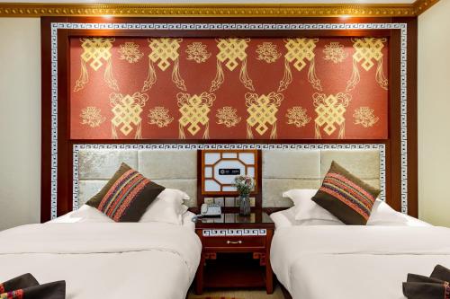two beds in a room with a wall at Floral Hotel · Shangri-la Blue Sky in Shangri-La