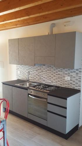 a kitchen with a stove and a sink at La Petite Maison in Gargnano