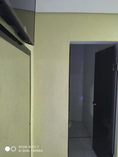 a bathroom stall with a black door and a white tile floor at Hotel motel Raiar do Sol santo Amaro in Sao Paulo
