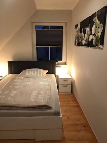 a bedroom with a white bed and a window at Le Casa de Jeune in Düsseldorf