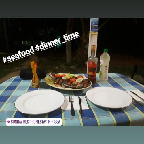 a table with two plates of food on it at SunRay Rest - Beach View Homestay in Mirissa