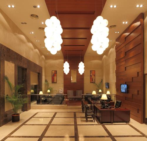 a lobby with chandeliers and a table and chairs at Mysore County Retreat in Mysore