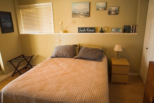 1 dormitorio con 1 cama con 2 almohadas en Inlet Beach House B&B, en North Saanich