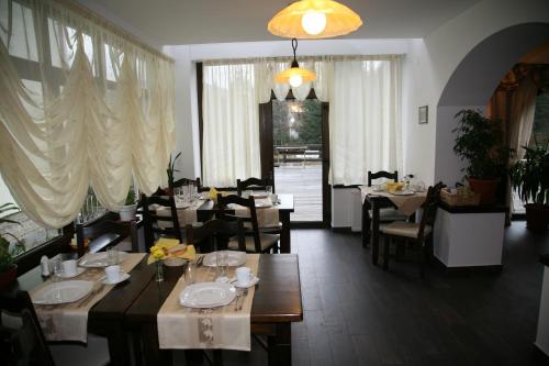 een restaurant met tafels en stoelen en een eetkamer bij Timis Valley, Casa Eni&Dan in Predeal