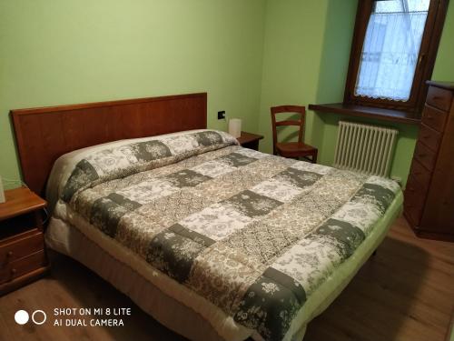 1 dormitorio con 1 cama con edredón en Deliziosa casetta, en Valpelline