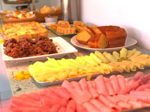 a table topped with plates of different types of food at Pousada Costeira da Barra in Maragogi