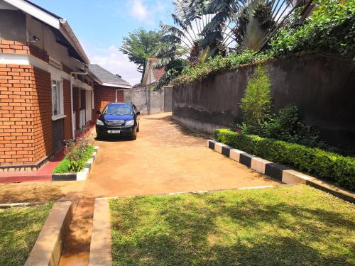 a car parked in a driveway next to a house at Kampala Ntinda Comfy Holiday Home in Kampala