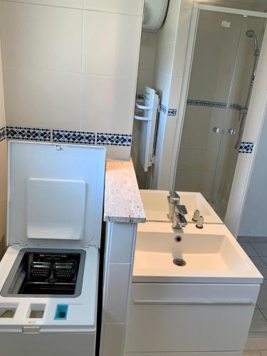 - une petite cuisine blanche avec un évier et un miroir dans l'établissement OntheRise Studio & terrasse vue mer - Palavas Centre, à Palavas-les-Flots