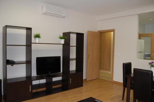 a living room with a flat screen tv on a shelf at Aparthotel Encasa in Madrid