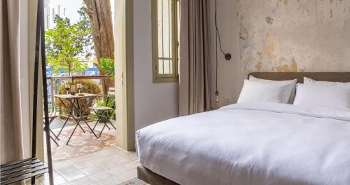 una camera da letto con un letto e un balcone con un tavolo di Ruby a Tel Aviv