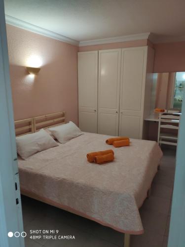 1 dormitorio con 1 cama con 2 almohadas de color naranja en Mareverde relax en Adeje