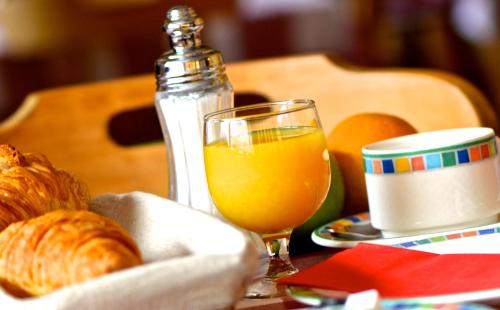 a table with a glass of orange juice and croissants at Hôtel Serre Palas in Les Deux Alpes