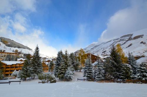 a group of trees in the snow in front of a building at Hôtel Serre Palas in Les Deux Alpes